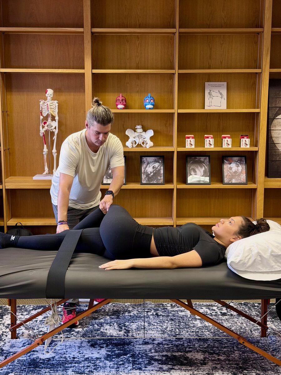 Therapist performing assisted hip stretch on client at Stretch Therapy HTX