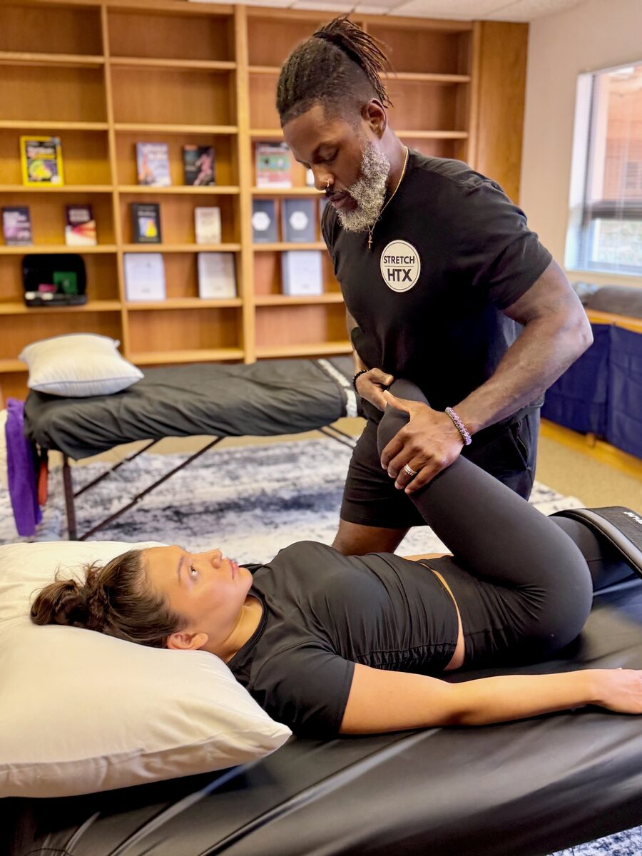 Aaron performing an assisted hip stretch at Stretch Therapy HTX