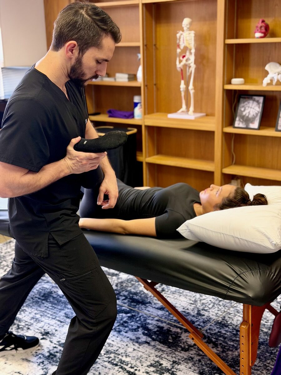 Joan performing an assisted arm stretch at Stretch Therapy HTX